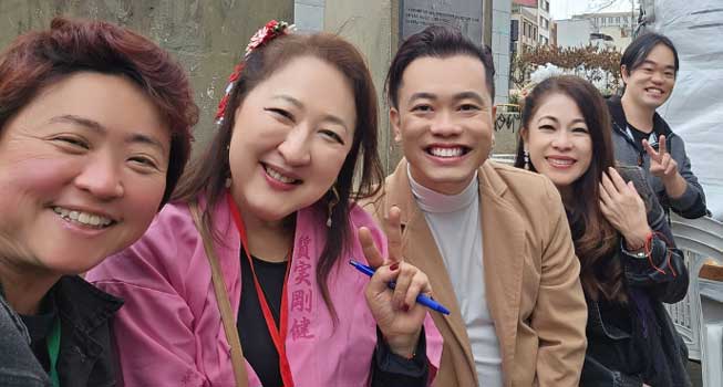 Cinco pessoas japonesas posando para a câmera sorridentes, incluindo dois homens e três mulheres